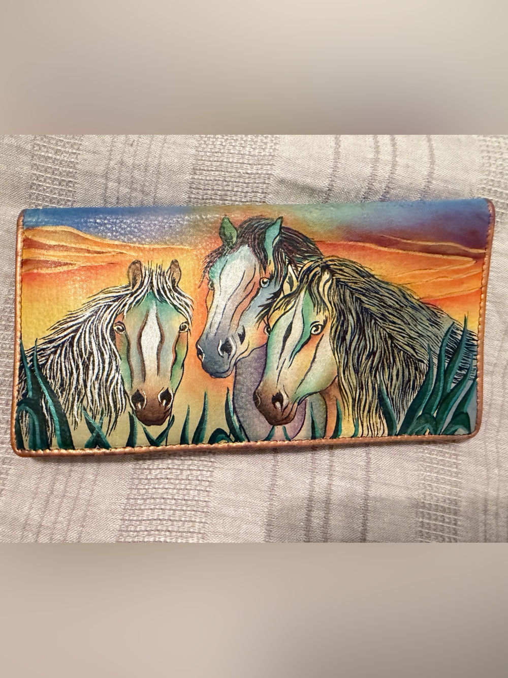Anuschka hand-painted leather wallet featuring a vibrant "sunset horses" design